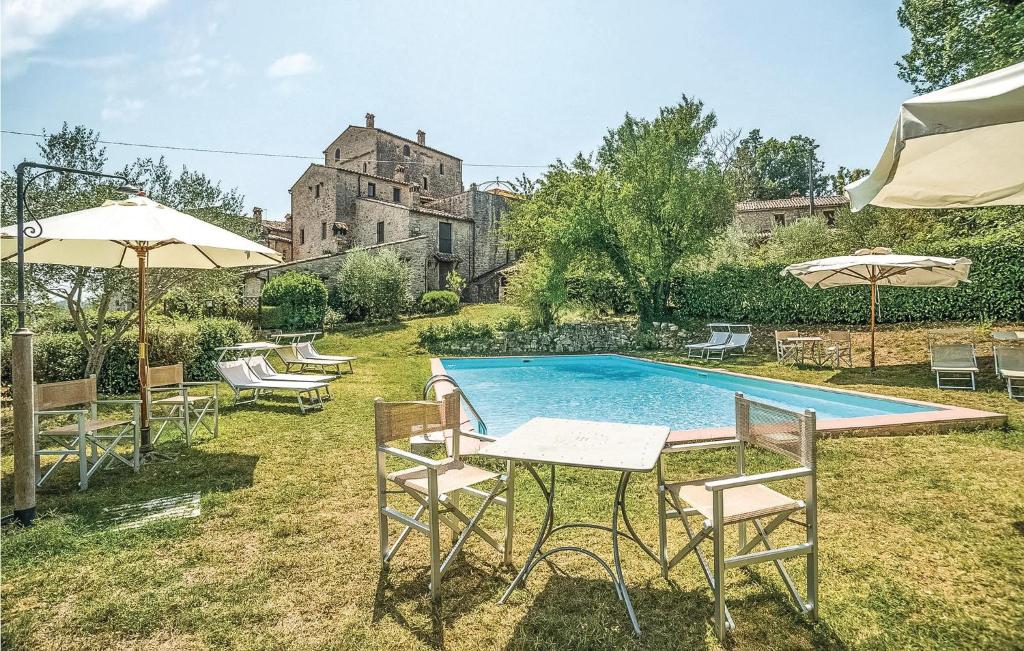 een zwembad met stoelen, tafels en parasols bij Ilaria in Vasciano Nuovo