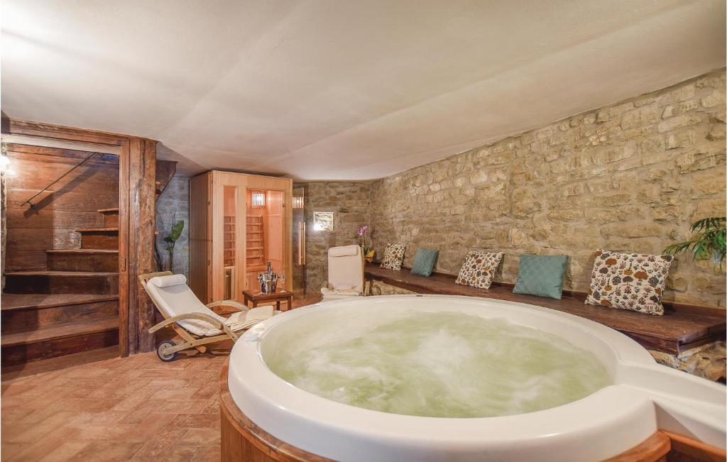 - une grande salle de bains pourvue d'une grande baignoire dans l'établissement 1 Bedroom Beautiful Home In Comano ms, à Comano