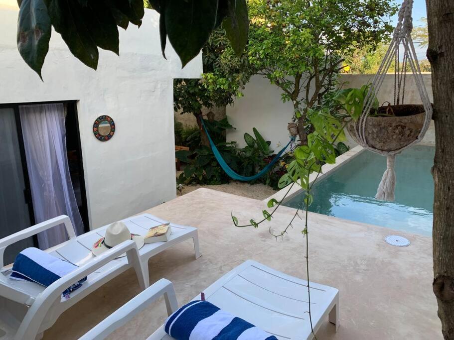 a patio with a swing and a swimming pool at Private Full House with pool and cozy patio in Valladolid