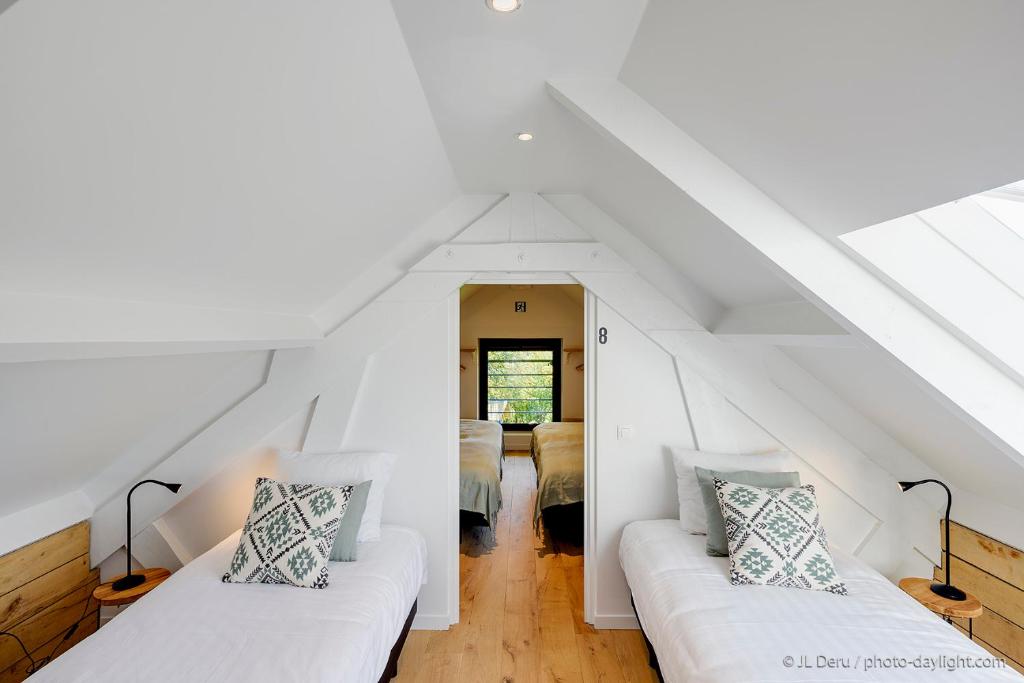 a room with two white couches in a attic at Chambres d&#39;Hôtes - La terrasse Bayehon - Ovifat in Waimes