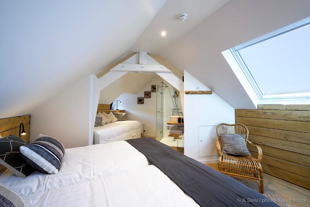 a attic bedroom with a bed and a window at Chambres d&#39;Hôtes - La terrasse Bayehon - Ovifat in Waimes