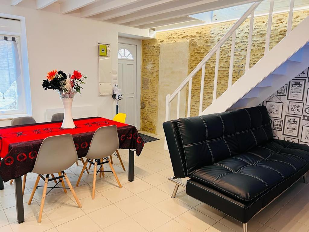 a living room with a table with a vase of flowers on it at Maison 2 pas du centre ville et proche plage in Courseulles-sur-Mer