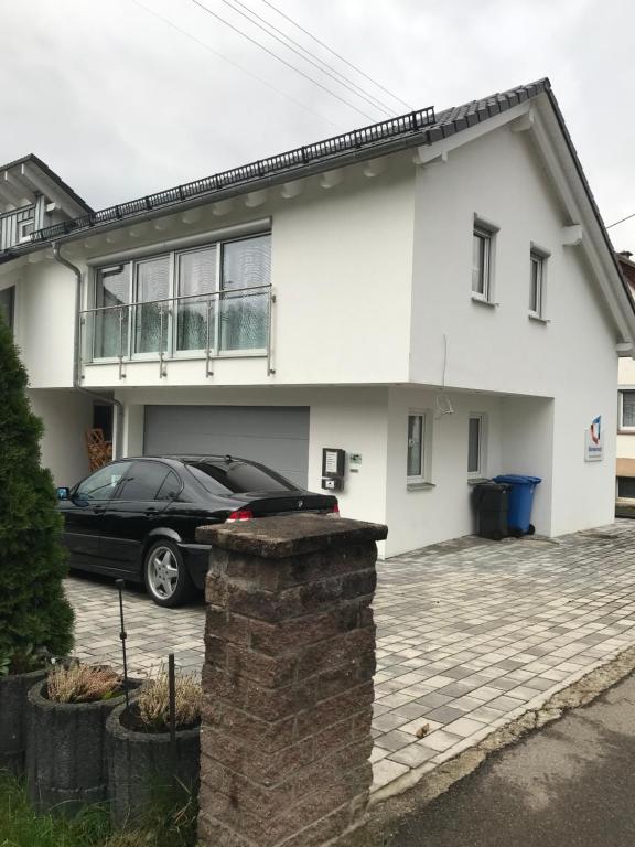 a black car parked in front of a white house at Jeannette in Balingen