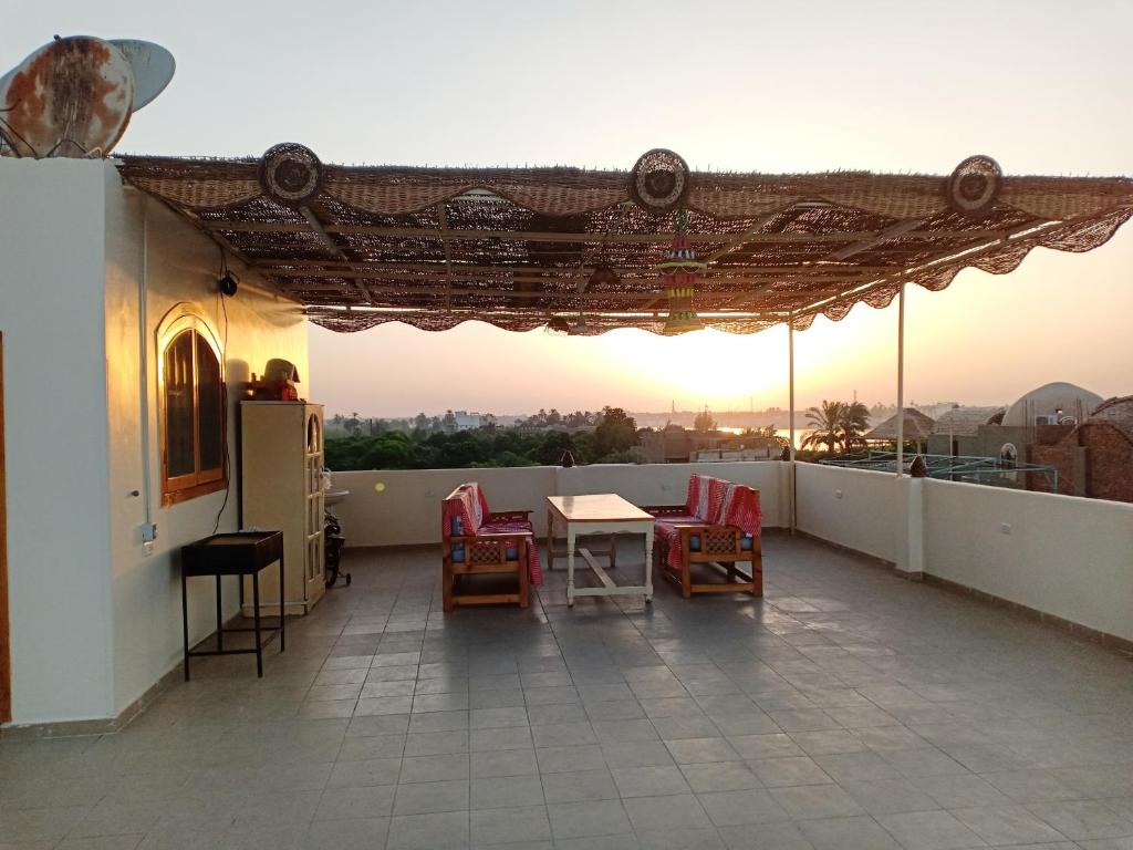 eine Terrasse mit einem Tisch und Stühlen auf dem Dach in der Unterkunft The Magic of Luxor private studio apartment on the rooftop in Luxor