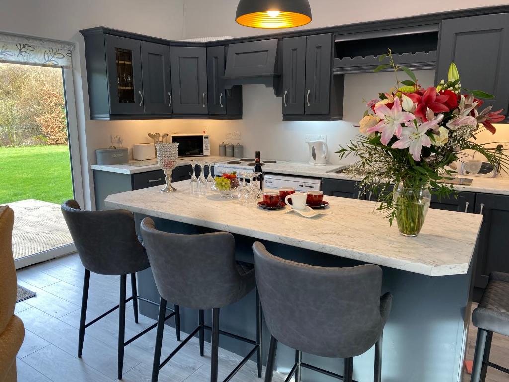 a kitchen with a center island with a vase of flowers at Duiche an Rí - Delightful Village Home in Tipperary