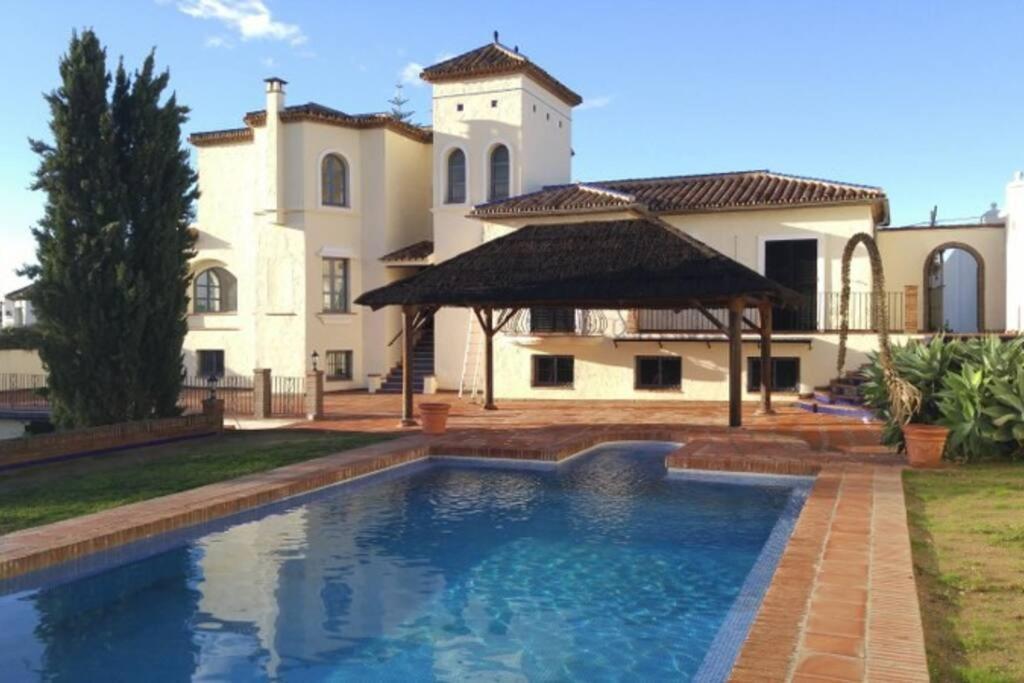 a large swimming pool in front of a house at Amazing villa to rent at Estepona - near beaches in Estepona