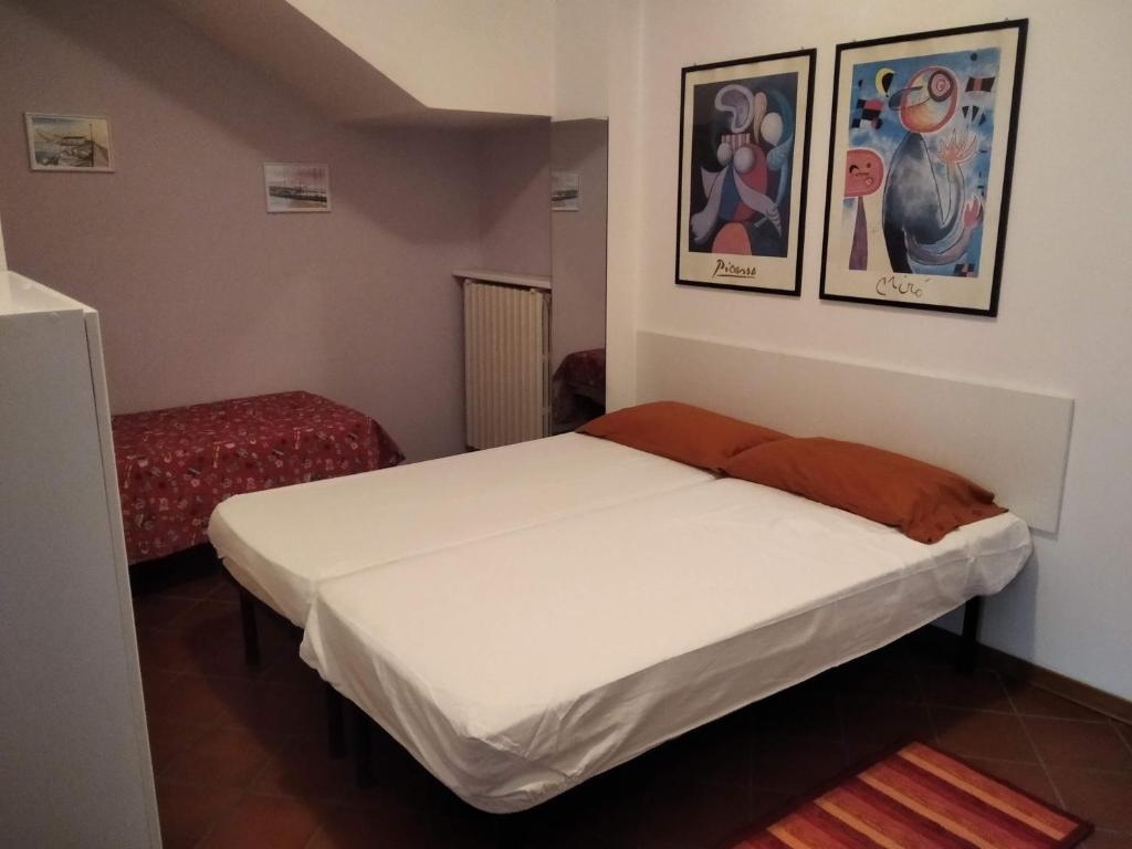 a bed in a room with two pictures on the wall at Darecco house in Cesenatico