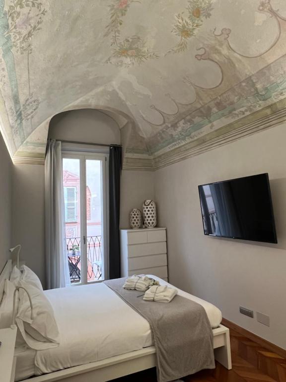a bedroom with a bed and a tv on a ceiling at Arco Antico in Alba