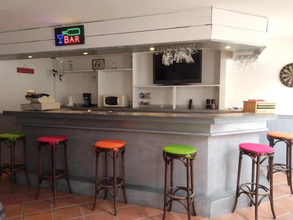 un bar con sgabelli colorati in un ristorante di Ancien Bar Lémon Café a Sainte-Anne-d'Auray