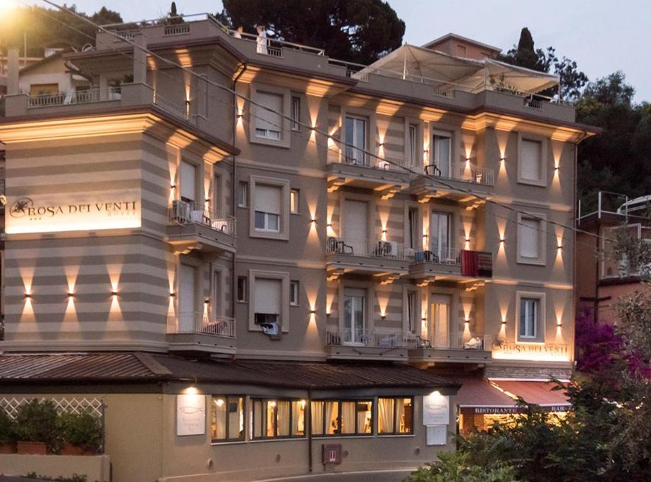 Un grand bâtiment blanc avec des lumières sur lui dans l'établissement Hotel Rosa Dei Venti, à Lerici