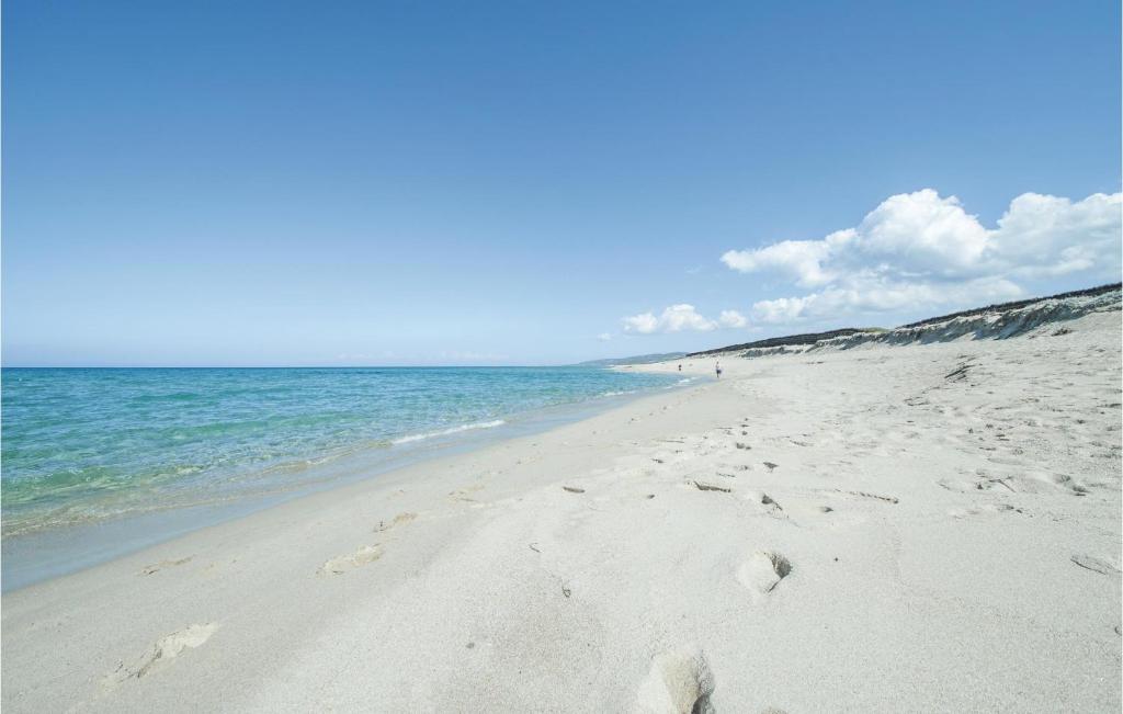 a beach with footprints in the sand and the ocean at Casa Cubo in Flussio