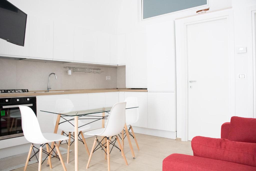 a kitchen with a glass table and white chairs at Dimora Vanni "civico 5" "civico 9" in Polignano a Mare