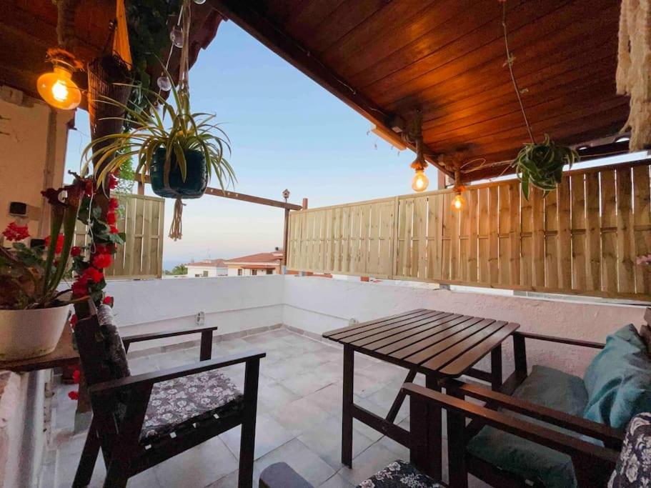 un patio con tavolo in legno e 2 sedie di Casa Dionea, Puerto De La Cruz a Puerto de la Cruz