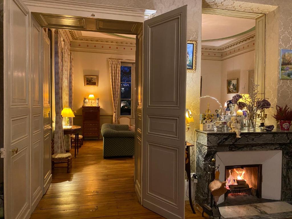 a hallway with a fireplace in a living room at B&amp;B Château de Preuil in Vallenay