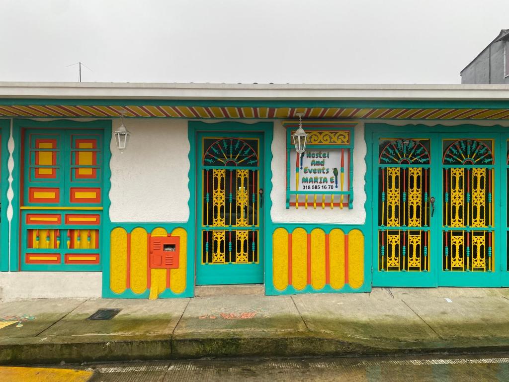 - un bâtiment avec des portes et des fenêtres colorées dans une rue dans l'établissement Casa Familiar María E, à Filandia