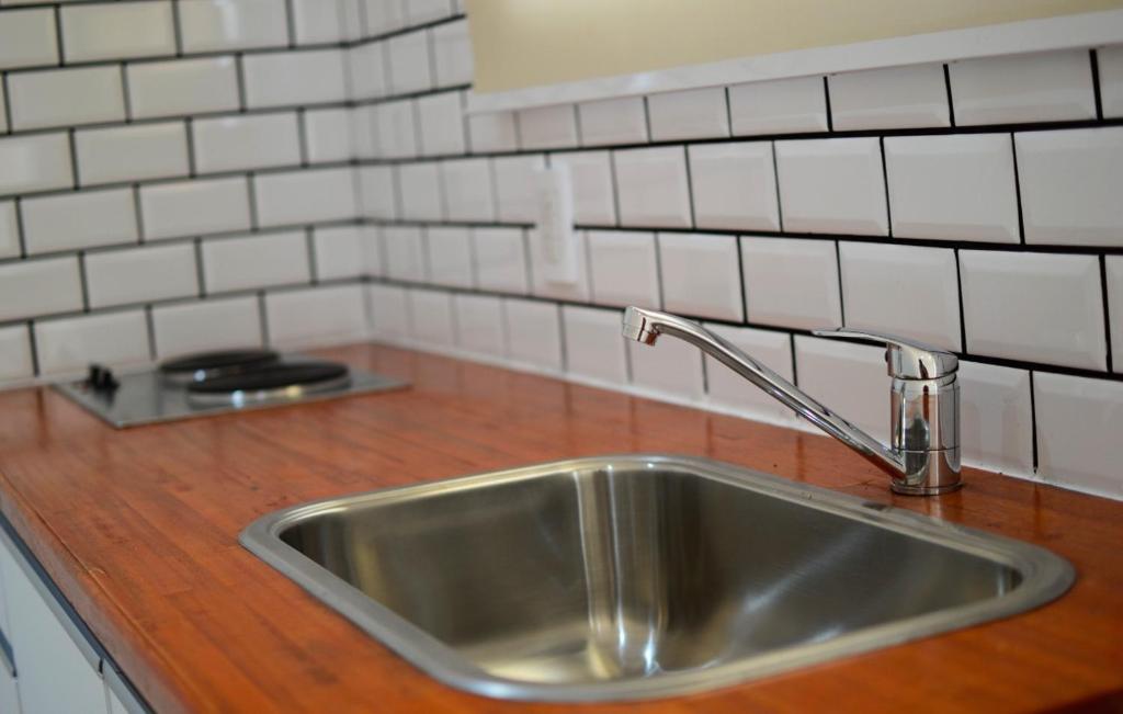 a stainless steel sink in a kitchen with white tiles at Apart SmartBox in Campana
