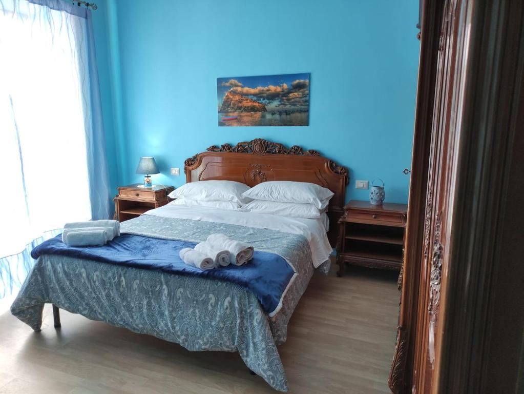 een slaapkamer met een bed met een blauwe muur bij Napoli Royal Suite in Napels