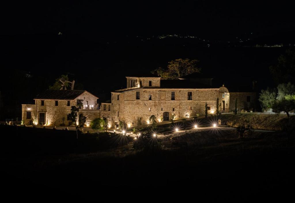 an old stone building with lights at night at Castello di Petecciano B&B in Mosciano SantʼAngelo