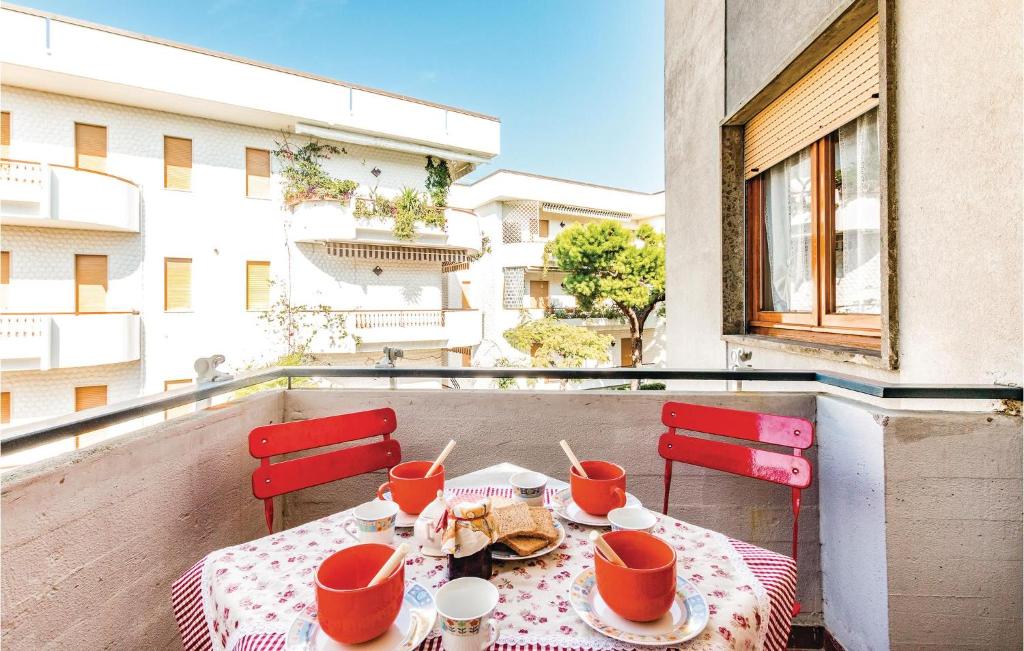 アルバ・アドリアティカにある2 Bedroom Awesome Apartment In Villa Rosa Teのテーブル(食べ物付)、バルコニー(赤い椅子付)