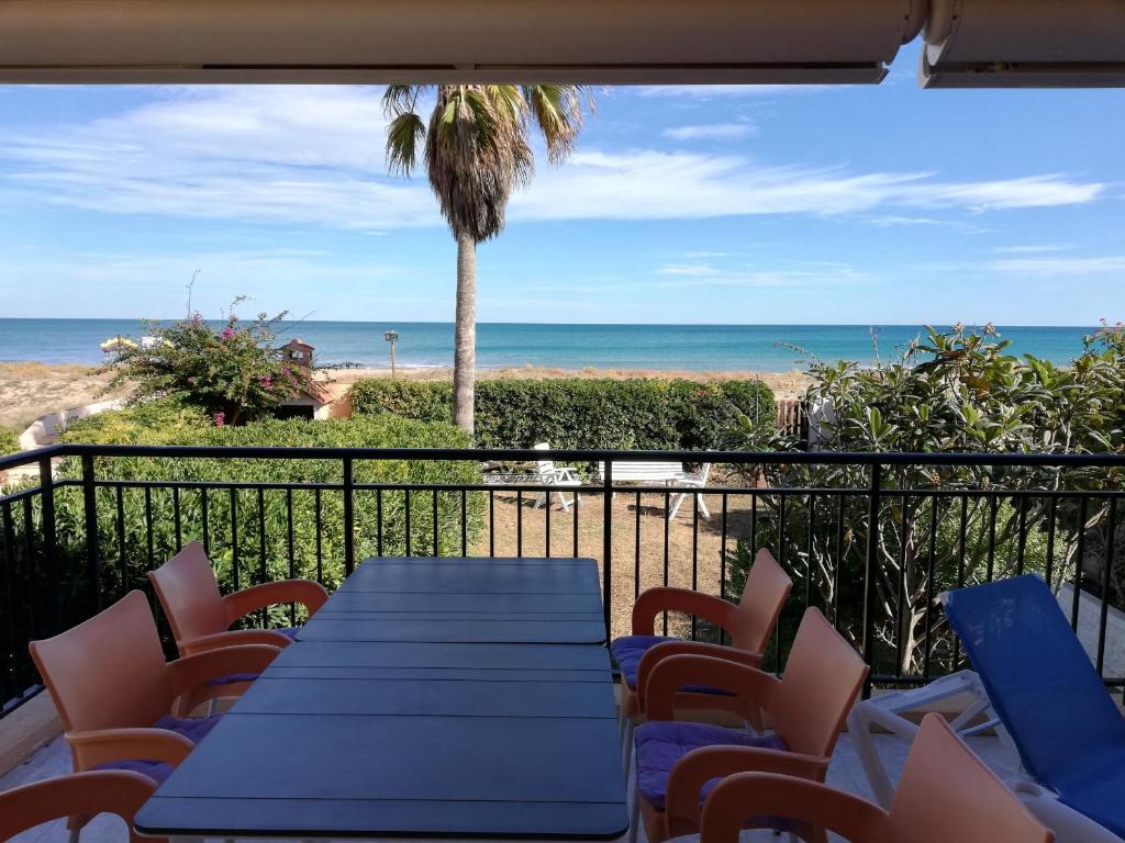 a table and chairs on a balcony with the beach at Oasis Solo Familias Serviplaya in Playa de Xeraco