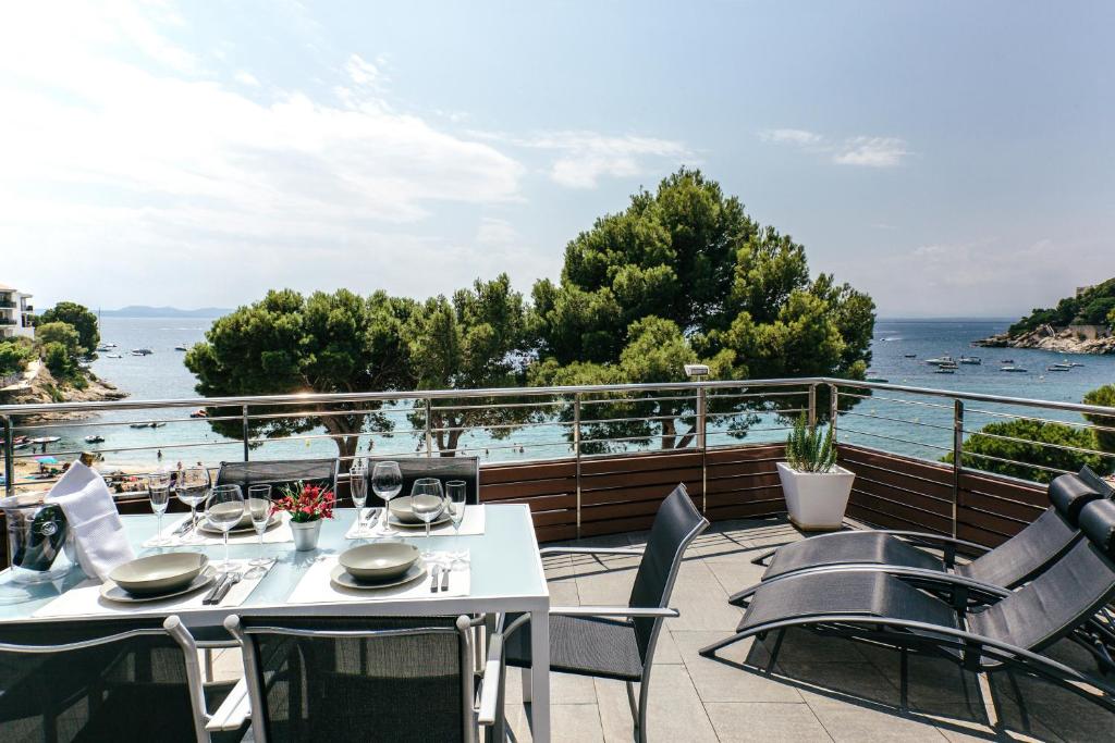 un patio con mesas y sillas y vistas al océano en Vista Roses Mar - El Molí, en Roses