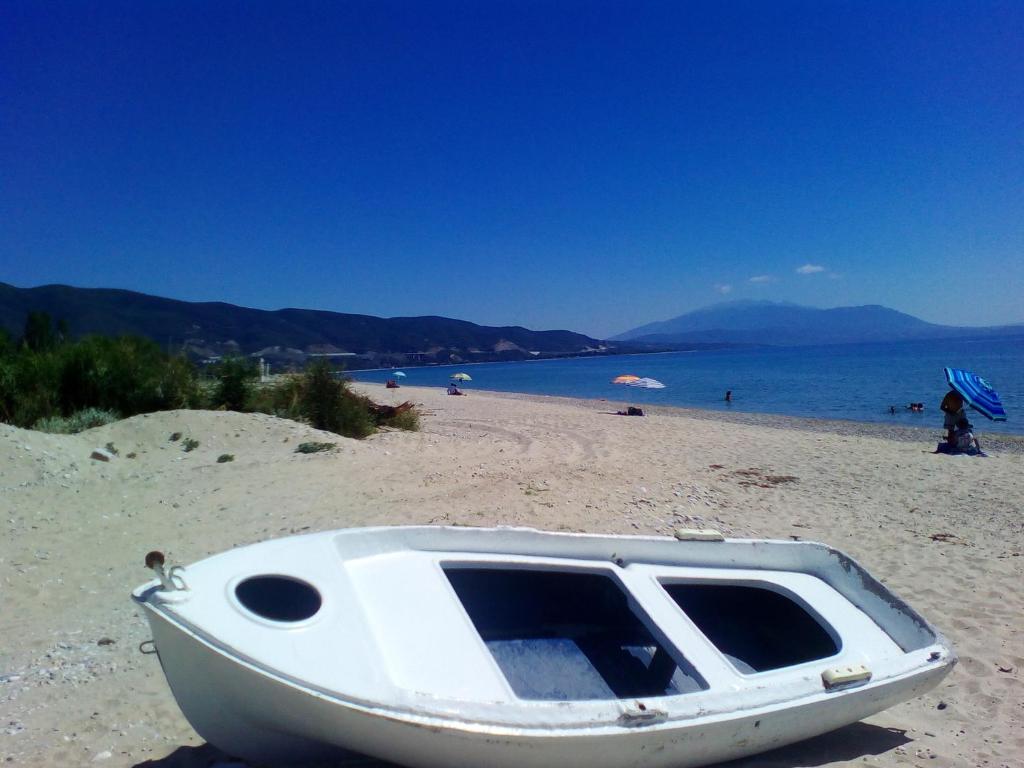 ein weißes Boot am Sandstrand in der Unterkunft Greece Asprovalta Rooms Accomodation Apartment Hotel Petalo in Asprovalta