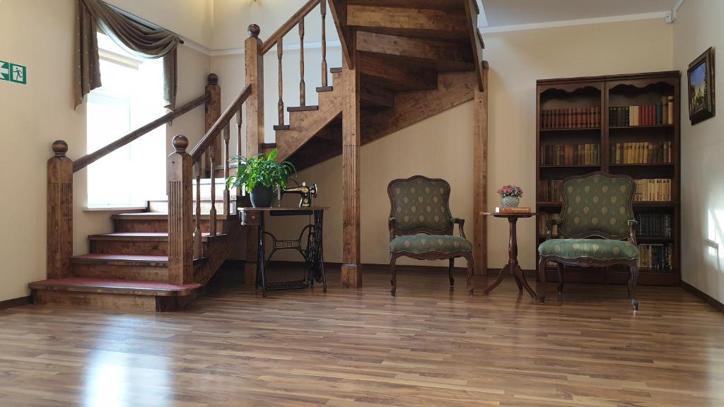 a living room with two chairs and a staircase at Külalistemaja Kukruse Residents in Kohtla-Järve