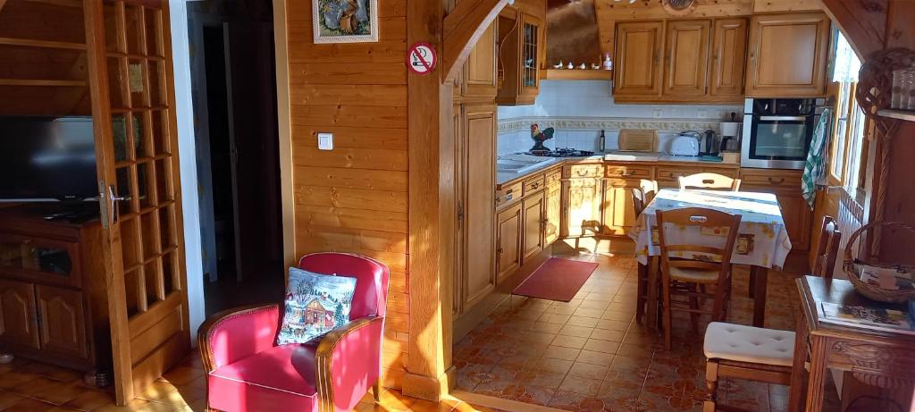 uma pequena cozinha com uma cadeira vermelha e uma mesa em Gîte du bel air em Festigny