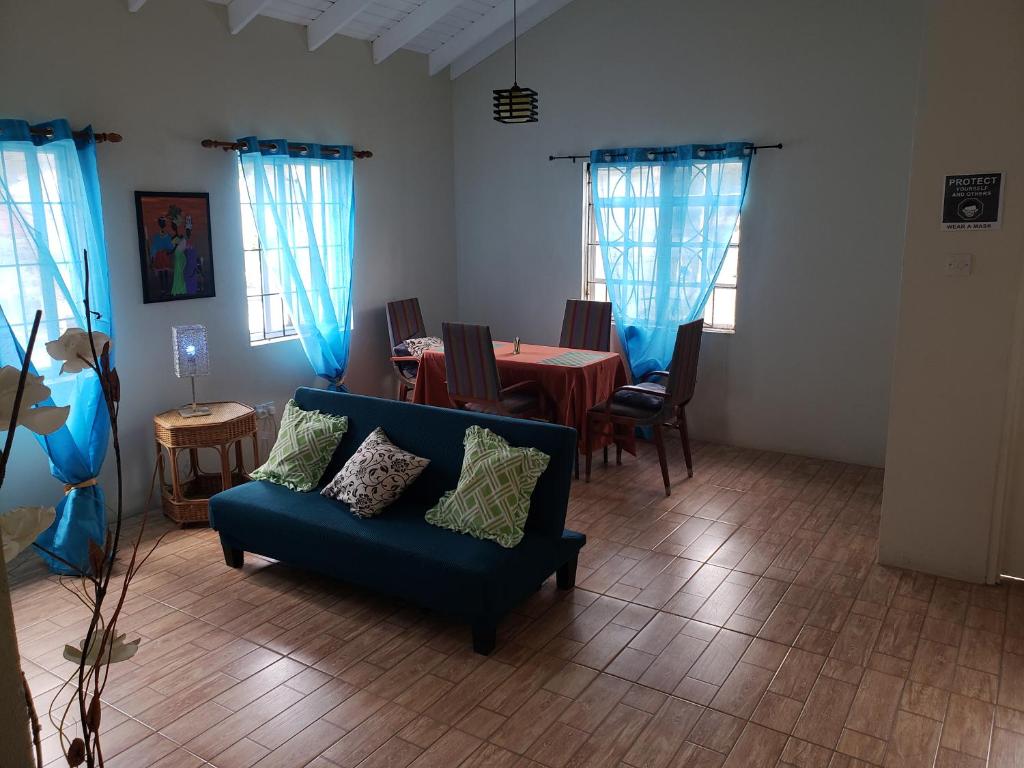 East Caribbean Lodging في جزيرة جورس: غرفة معيشة مع أريكة زرقاء وطاولة