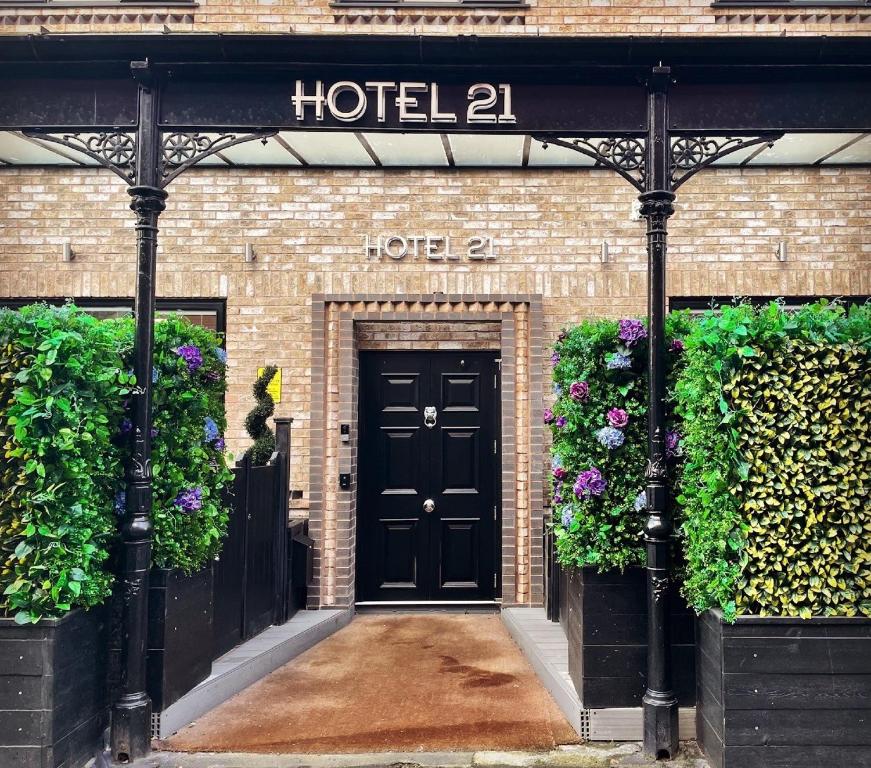 a hotel entrance with a black door and flowers at Hotel 21 in Southport