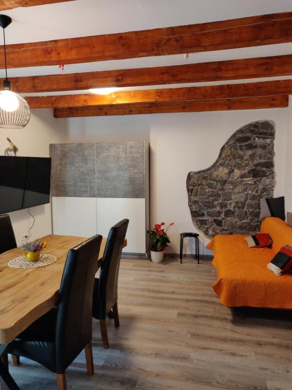 Homestead Zavadlal - Domačija Zavadlal في Komen: غرفة طعام مع طاولة وأريكة