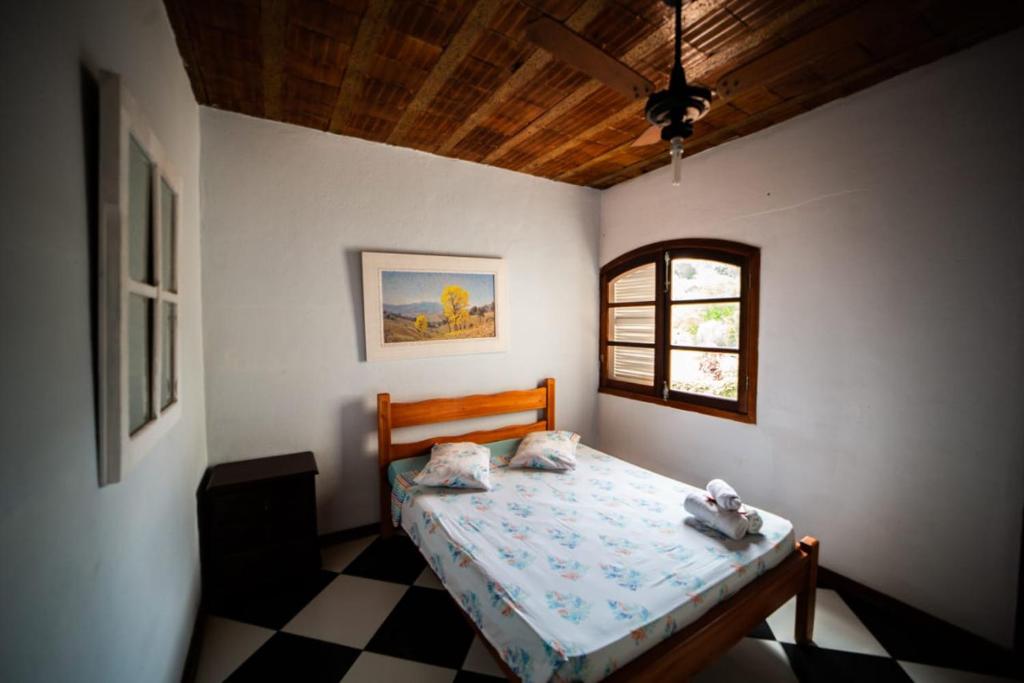 1 dormitorio con 1 cama y suelo a cuadros en Pousada do Ipê, en São Lourenço