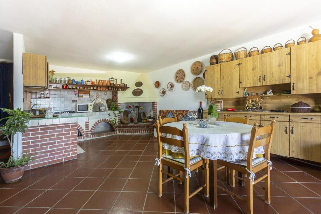 a kitchen with a table and wooden cabinets at Il tramonto visto da casa in Calasetta