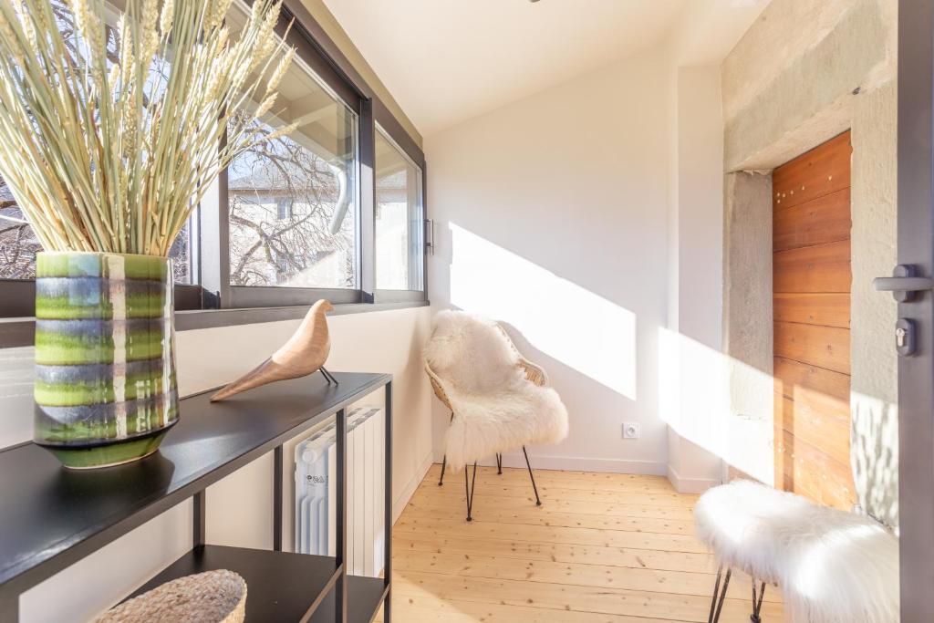 a hallway with two chairs and a table and a window at Les Tours Carrées in La Motte-Servolex