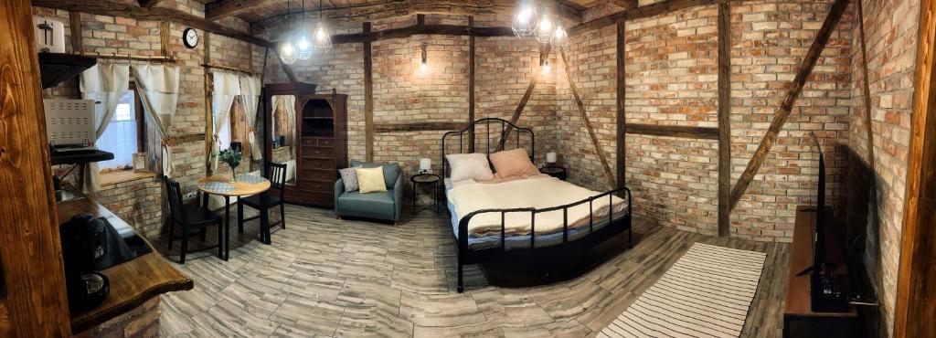 Cette chambre dispose d'un lit dans un mur en briques. dans l'établissement Mátrai Vadászház 3-Vintage Cottage, à Mátraterenye