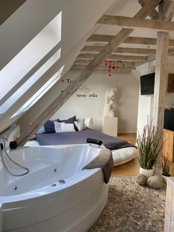 een groot bad in een kamer met een bed bij private Wellness Suiten mit Whirlpool in Essen