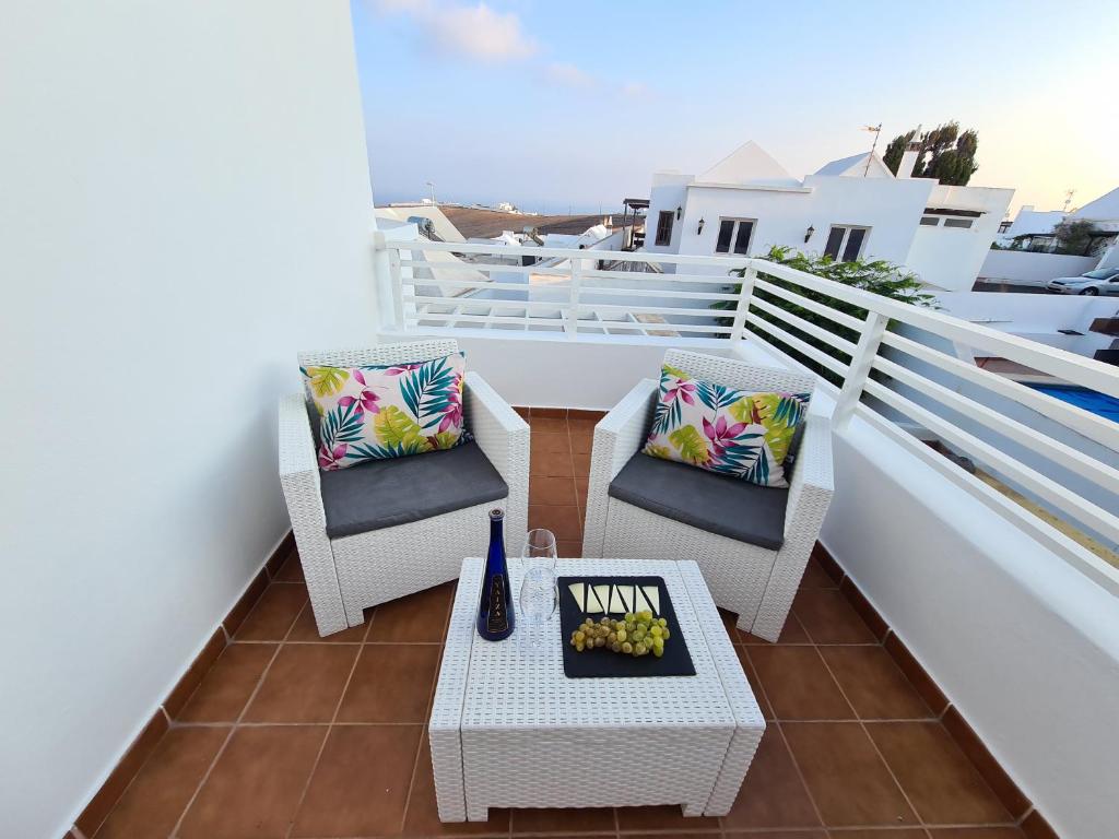 a balcony with chairs and a table with a bowl of fruit at Mandala in Tías