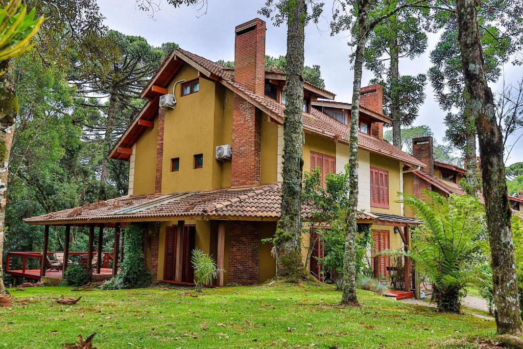 ein großes Haus mit Bäumen davor in der Unterkunft LOCAR-IN CANELA - Tríplex Laje de Pedra in Canela