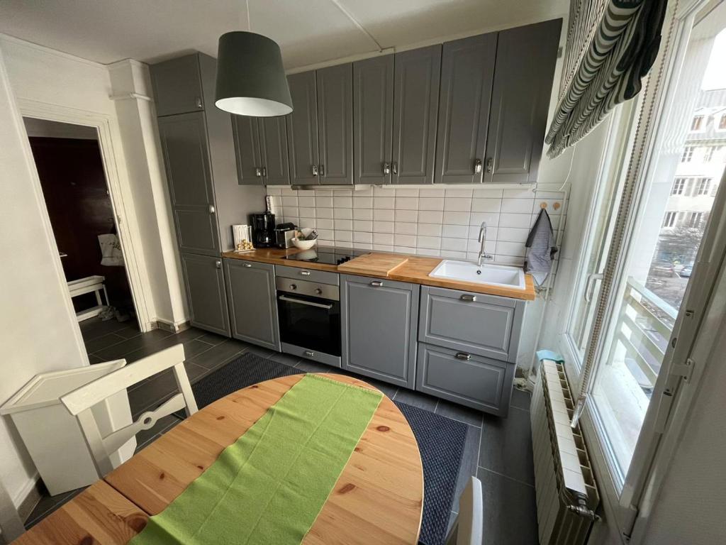 een keuken met een houten tafel en een wastafel bij Superbe appartement au hypercentre de Chambéry in Chambéry