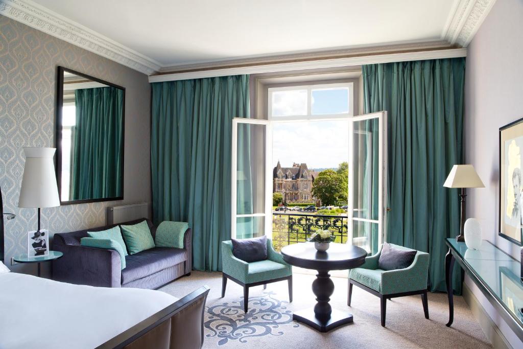 a hotel room with a bed and a window at Le Grand Hotel de Cabourg - MGallery Collection in Cabourg