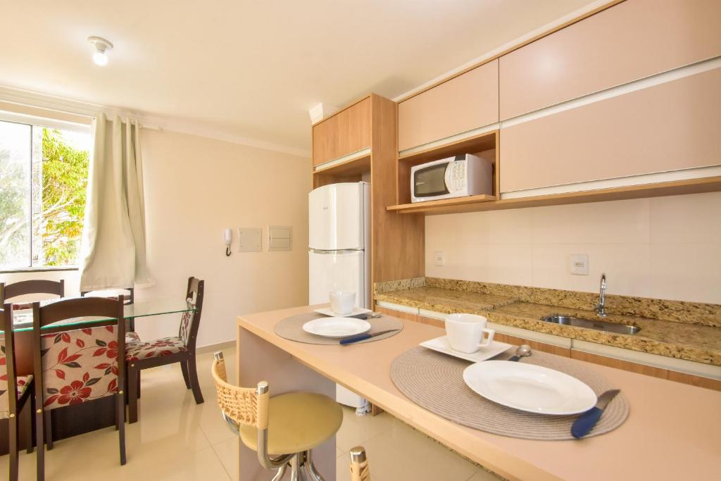 eine Küche mit einem Tisch mit zwei Platten drauf in der Unterkunft Apartamento a 3 min do mar nos Ingleses Norte P154 in Florianópolis
