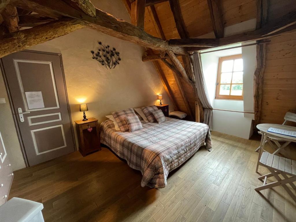 a bedroom with a bed and a window at Chambre d'hôtes La Ferme de la Croix. in Saint-Avit-Sénieur
