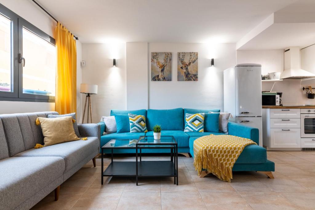 uma sala de estar com um sofá azul e uma mesa em Casa Cotillo 13 next to Los Lagos Beach Highspeed Wifi em Cotillo
