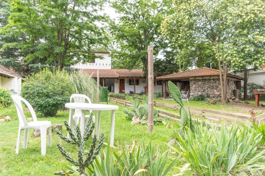 a table and chairs in a yard with a house at Tacuifi I - Cabañas in Los Reartes