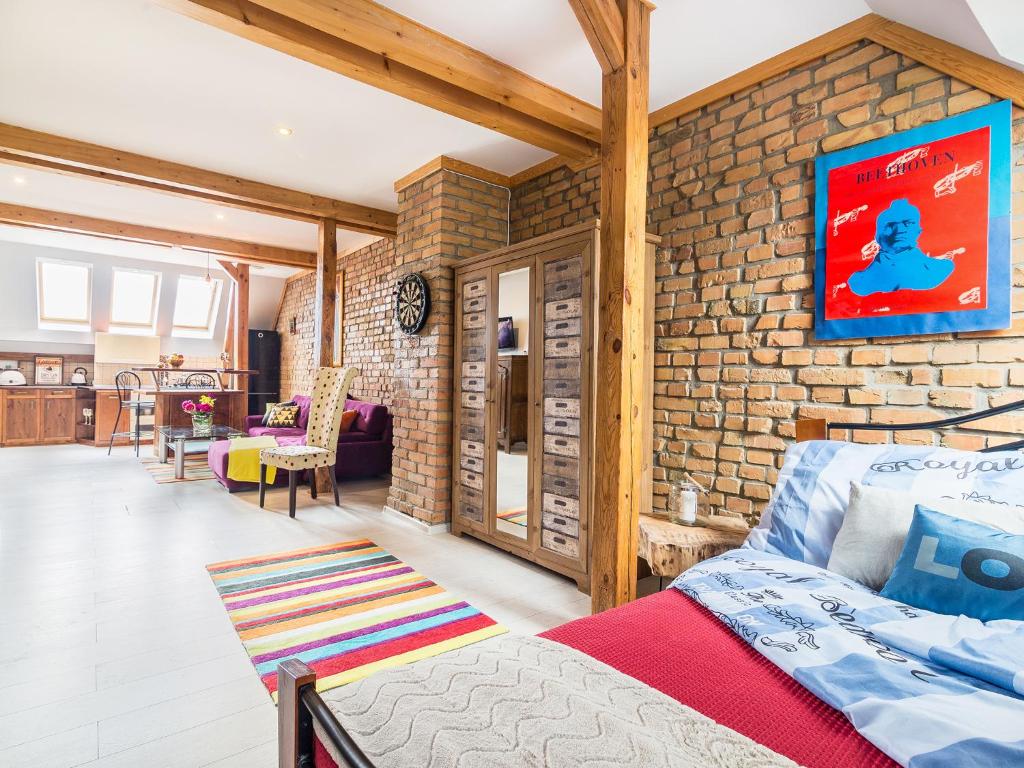 Zimmer mit Ziegelwand, Bett und Tisch in der Unterkunft Słoneczne Studio z widokiem na morze in Sopot