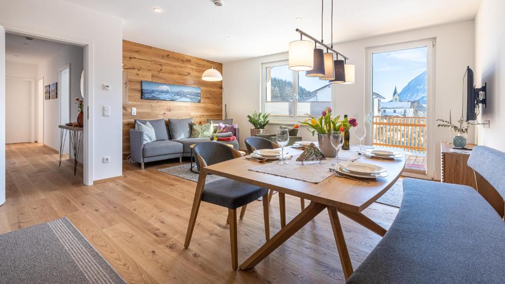 a dining room and living room with a table and chairs at Appartment Schöner Wohnen in Bad Mitterndorf