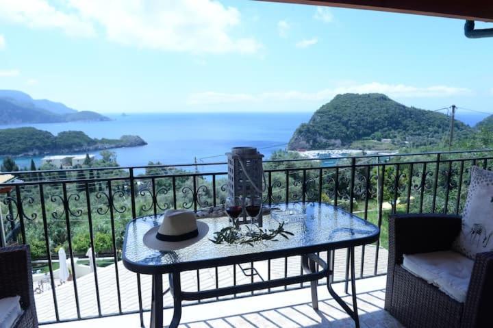 a table on a balcony with a view of the ocean at angela superior studio in Paleokastritsa