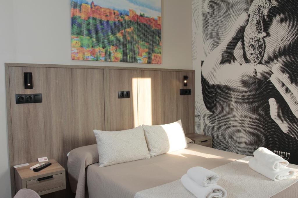 Una habitación de hotel con una cama con toallas. en Hospedium Hostal Temático Desde La Judería en Arjona