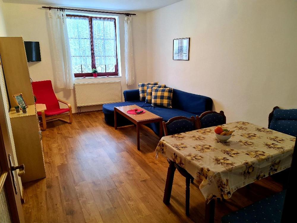 a living room with a blue couch and a table at Penzion Gerle in Černý Dŭl