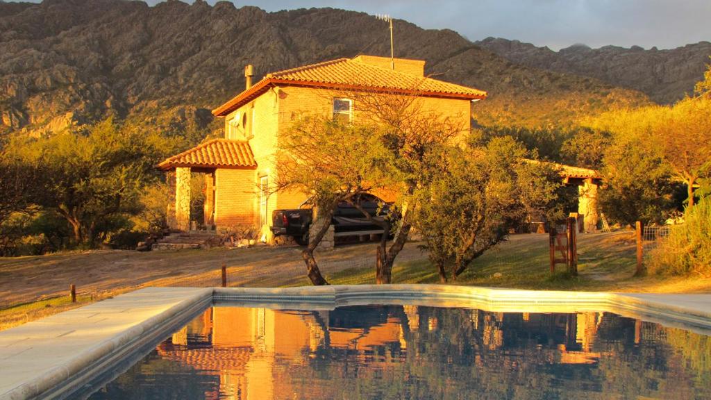 a house with a swimming pool in front of a house at Cabañas de Montaña San Miguel in Cortaderas